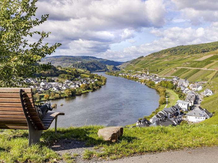Man sieht links eine Ruhebank. Der Blick geht auf die Mosel mit umliegenden Dörfern
