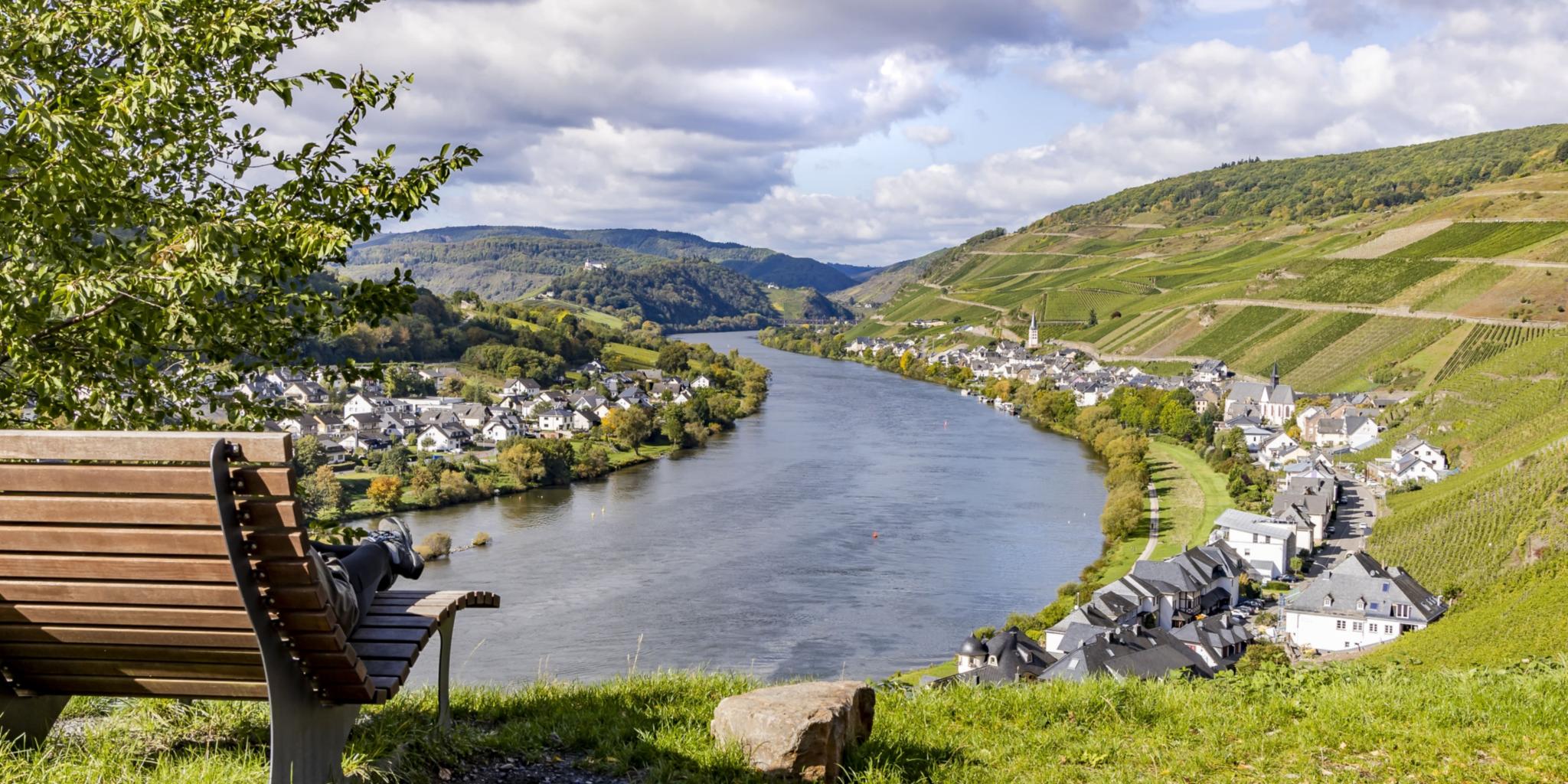 Man sieht links eine Ruhebank. Der Blick geht auf die Mosel mit umliegenden Dörfern