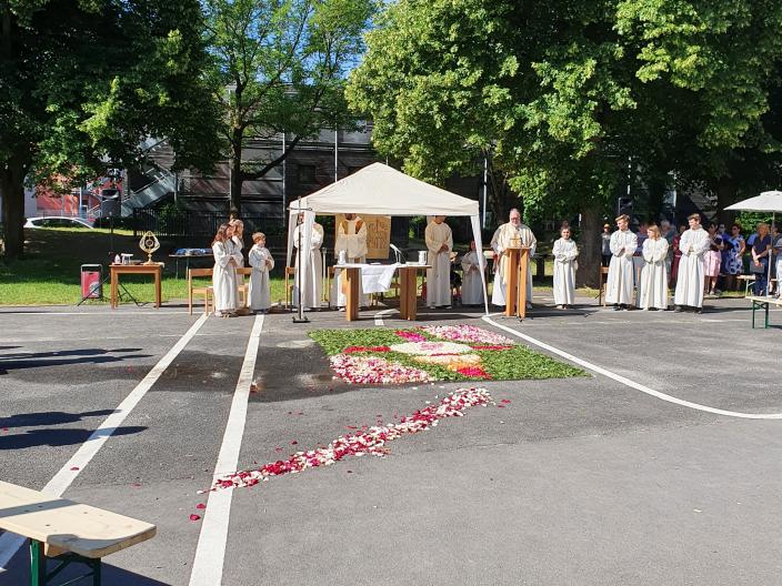 im Vordergrund der Schulhof vor der Kirche, im Hintergrund das Zelt