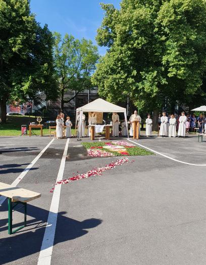 im Vordergrund der Schulhof vor der Kirche, im Hintergrund das Zelt