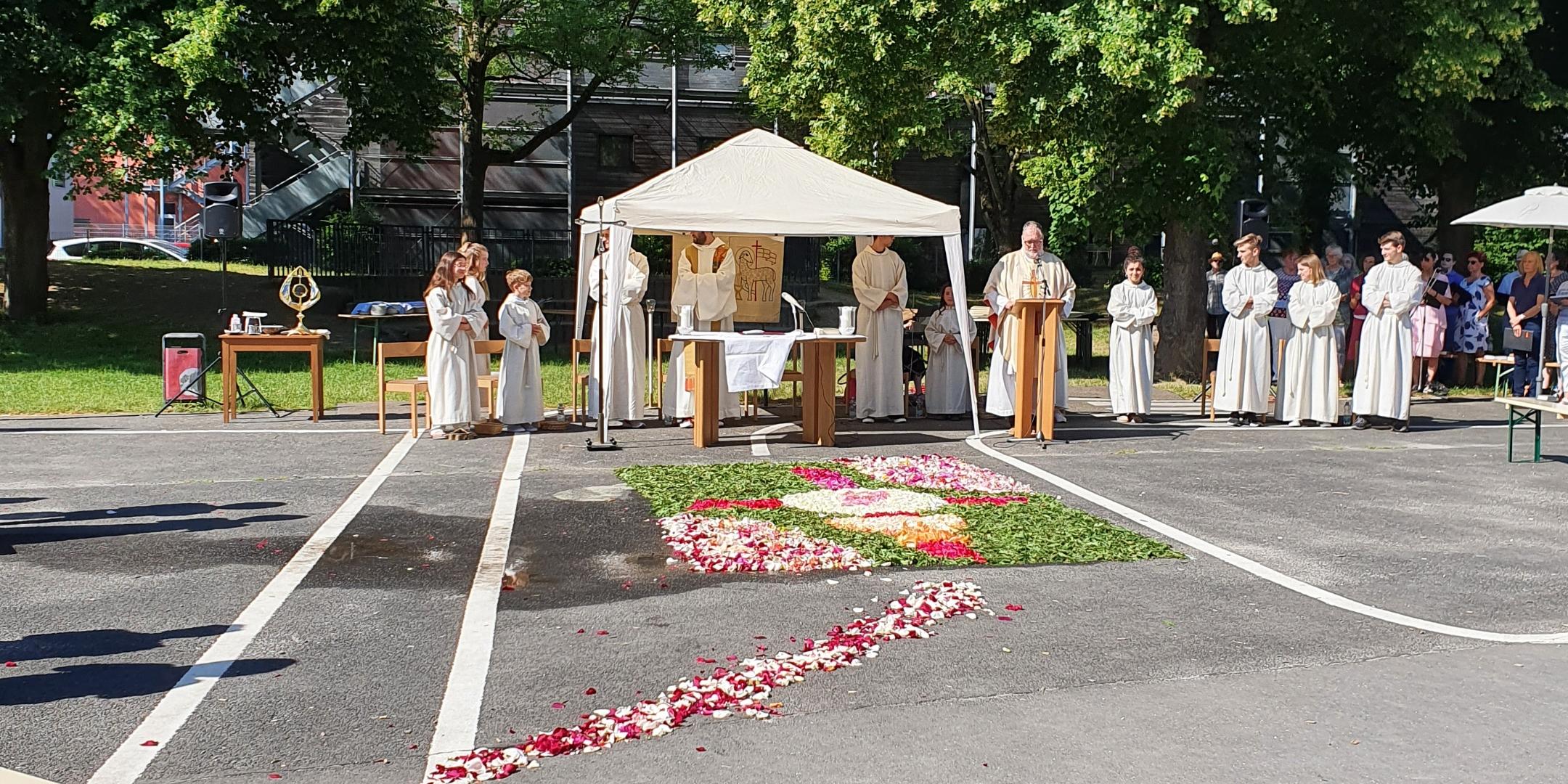 im Vordergrund der Schulhof vor der Kirche, im Hintergrund das Zelt