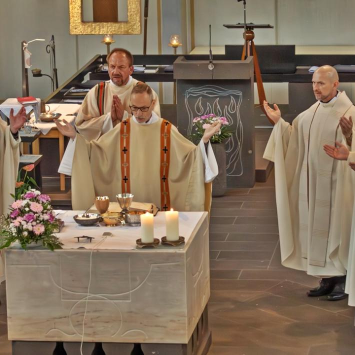 zentral ist der Altar der Kirche St. Franziskus, Koblenz zu sehen, dahinter Priester Heinz-Peter Wilbertz und weitere Pastöre, die im Halbreis um ihn stehen