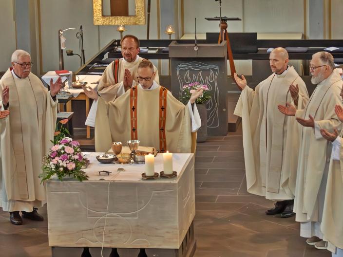 zentral ist der Altar der Kirche St. Franziskus, Koblenz zu sehen, dahinter Priester Heinz-Peter Wilbertz und weitere Pastöre, die im Halbreis um ihn stehen