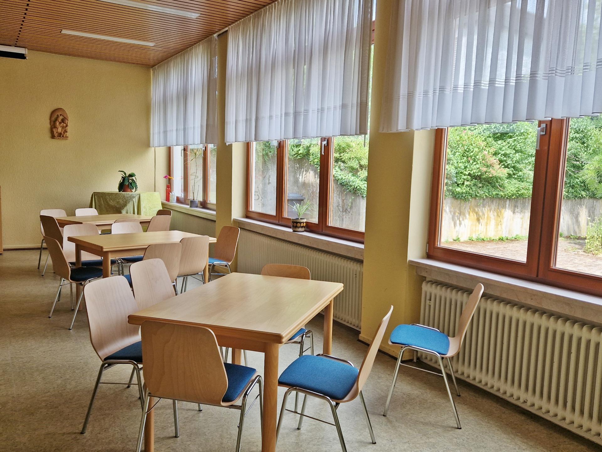 Begegnungsstätte St. Martinus Tische Innenansicht der Begegnungsstätte St. Martinus Tische vor der Fensterfront