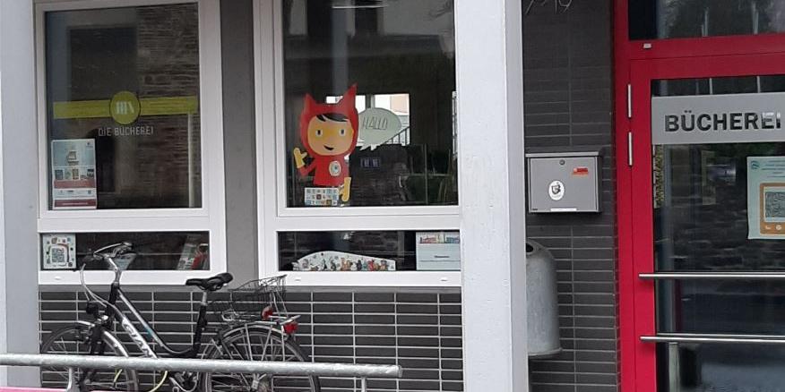Blick auf die Eingangstür und 2 Fenster, davor steht ein Fahrrad. Ein Fenster ist mit dem Schriftzug der Bücherei beklebt (c) KÖB Koblenz-Moselweiß Blick auf die Eingangstür und 2 Fenster, davor steht ein Fahrrad. Ein Fenster ist mit dem Schriftzug der Bücherei beklebt