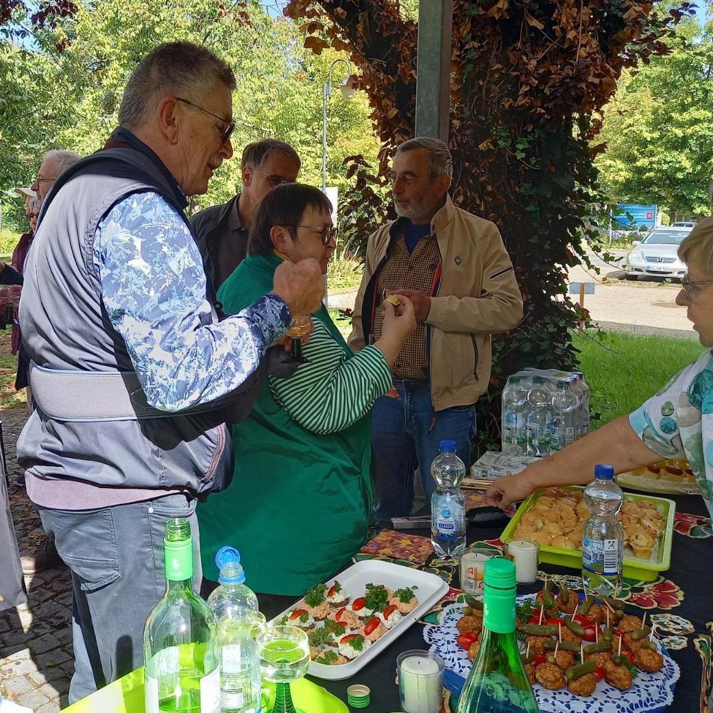 Buffet nach dem Pilgerspaziergang Ein im Freien aufgebautes Buffet mit schön angerichteten Häppchen, davor stehen Personen