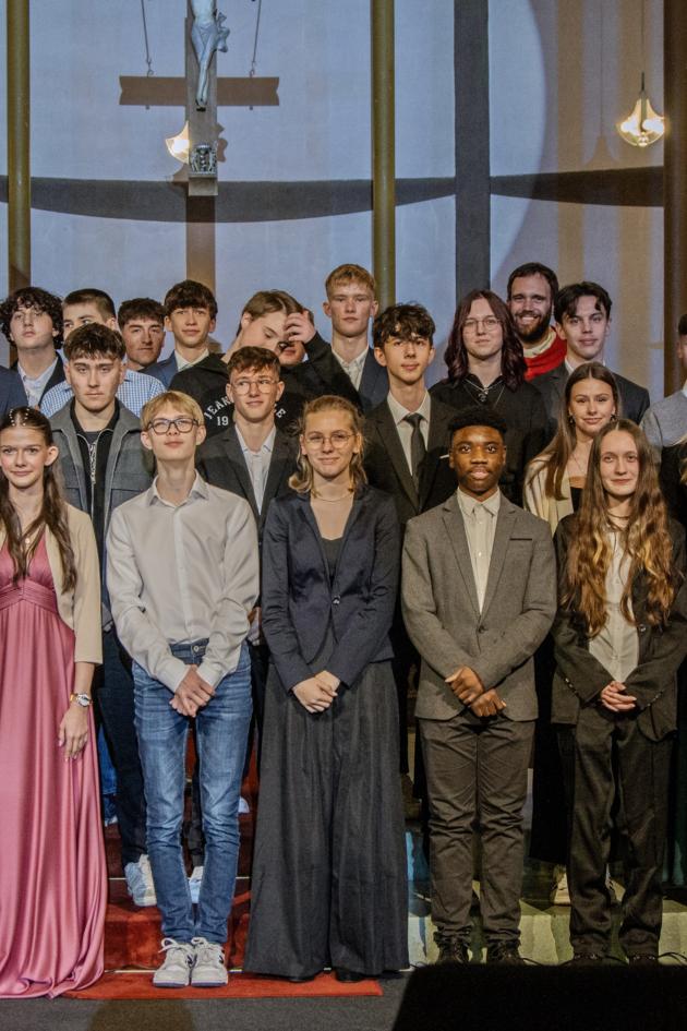 Gruppenfoto der Firmlinge im Hintergrund steht Firmspender Dominic Lück