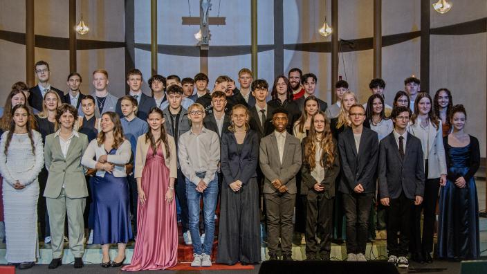 Gruppenfoto der Firmlinge im Hintergrund steht Firmspender Dominic Lück