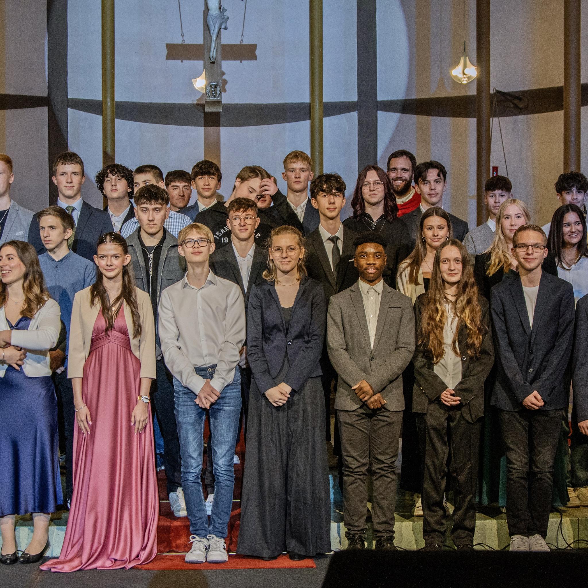 Gruppenfoto der Firmlinge im Hintergrund steht Firmspender Dominic Lück