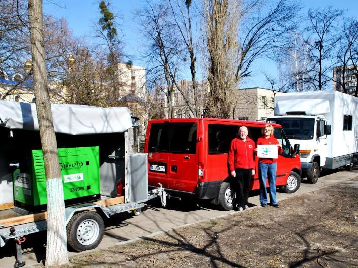 Zu sehen ist ein Transporter mit Anhänger auf dem der Stromgenerator geladen ist