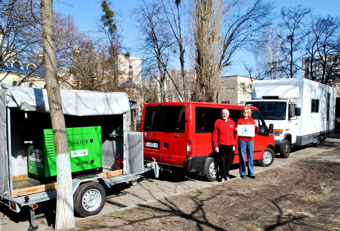 Zu sehen ist ein Transporter mit Anhänger auf dem der Stromgenerator geladen ist