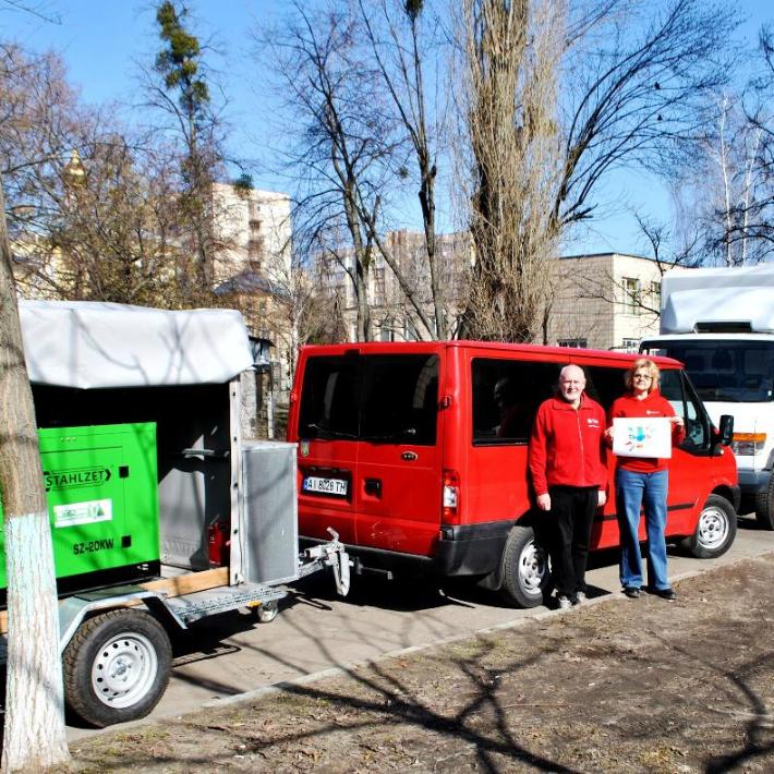 Zu sehen ist ein Transporter mit Anhänger auf dem der Stromgenerator geladen ist