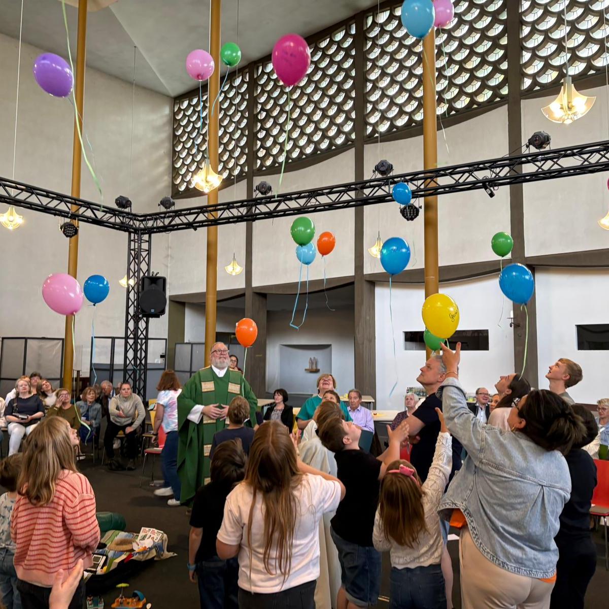 Kinder, Jugendliche, Erwachsene lassen im Gottesdienst in der St. Elisabeth Kirche, Koblenz Rauental bunte Luftballons steigen