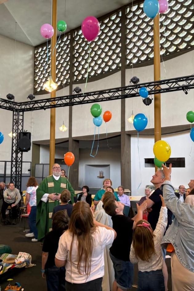 Kinder, Jugendliche, Erwachsene lassen im Gottesdienst in der St. Elisabeth Kirche, Koblenz Rauental bunte Luftballons steigen
