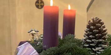 Adventkranz mit zwei brennenden Kerzen auf einem Ständer