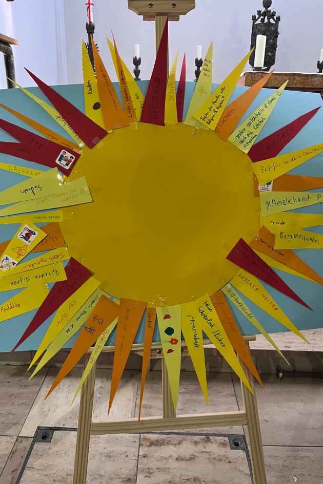 Auf einer Staffelei eine große Sonne aus gelbem Karton