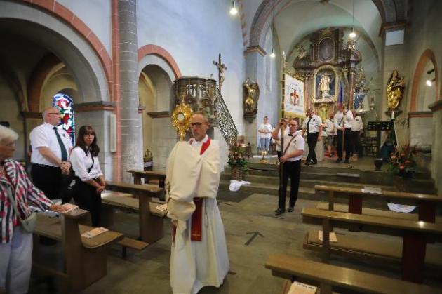 Einzug in die LaurenitusKirche nach der Kirmesprozession, Pastor trägt Monstranz und Fahnenabordnungen