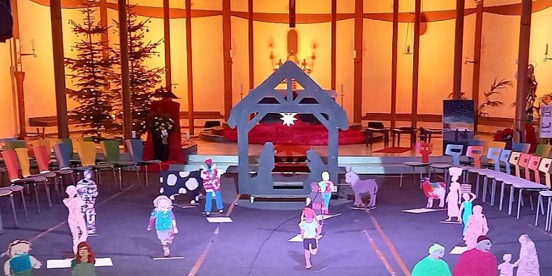 Vor dem in sanftem Licht beleuchteten Altarraum der St. Elisabethkirche steht eine außergewöhnliche Krippe. Wie ein Schwippbogen lebensgroß ist der Stall gestaltet  mit Maria und Josef zwischen ihnen ein Stern. Holzfiguren aus Brettern gesägt - als Menschen, die uns tagtäglich auf der Straße begegnen,  aber auch Ochs, Esel und Schaf kommen von der Krippe auf uns zu. Es entsteht das Gefühl auf einem Marktplatz oder auf einem Feld zu sein, denn dieses Krippe nimmt einen großen Raum ein.