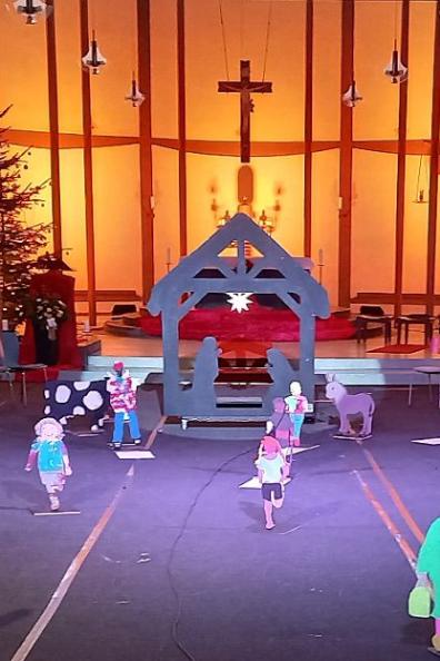 Vor dem in sanftem Licht beleuchteten Altarraum der St. Elisabethkirche steht eine außergewöhnliche Krippe. Wie ein Schwippbogen lebensgroß ist der Stall gestaltet  mit Maria und Josef zwischen ihnen ein Stern. Holzfiguren aus Brettern gesägt - als Menschen, die uns tagtäglich auf der Straße begegnen,  aber auch Ochs, Esel und Schaf kommen von der Krippe auf uns zu. Es entsteht das Gefühl auf einem Marktplatz oder auf einem Feld zu sein, denn dieses Krippe nimmt einen großen Raum ein.