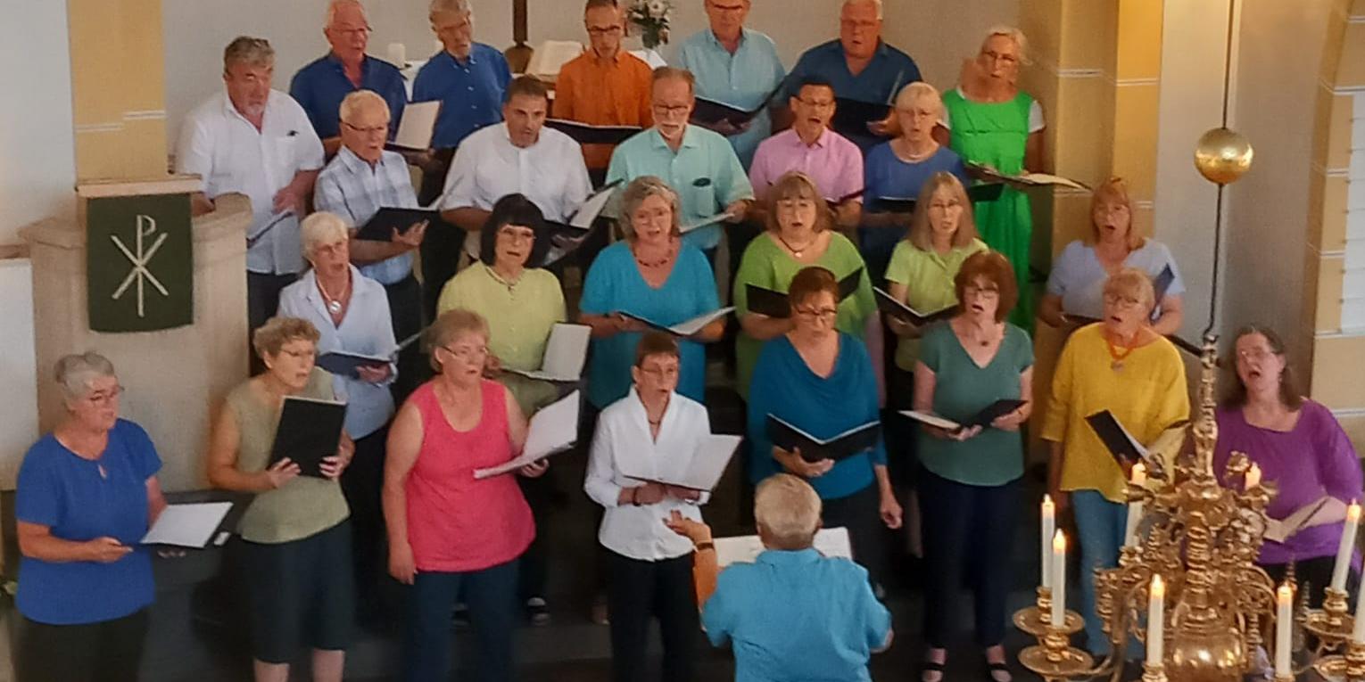 Männer und Frauen die mit Begeisterung in einer Kirche in Winningen singen