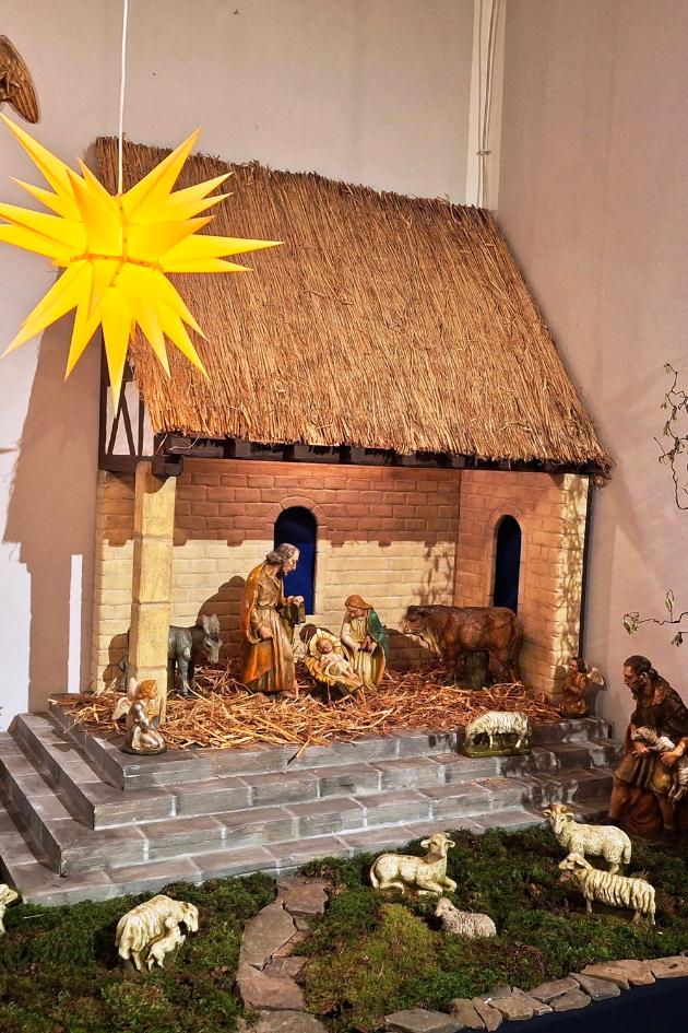 Die Krippe ist rechts neben dem Altarrraum St. Beatus zu sehen, sie besteht aus einem großen offenen Stall mit Strohdach, zu dem Stufen hinaufführen. Unten um die Stufen ist Moos, in dem Hirten mit ihren Schafen zu sehen sind. In dem Stall  sind Maria, Josef, das Jesuskind in der Krippe sowie ein Ochse und ein Esel zu sehen. Im Vordergrund hängt ein Stern