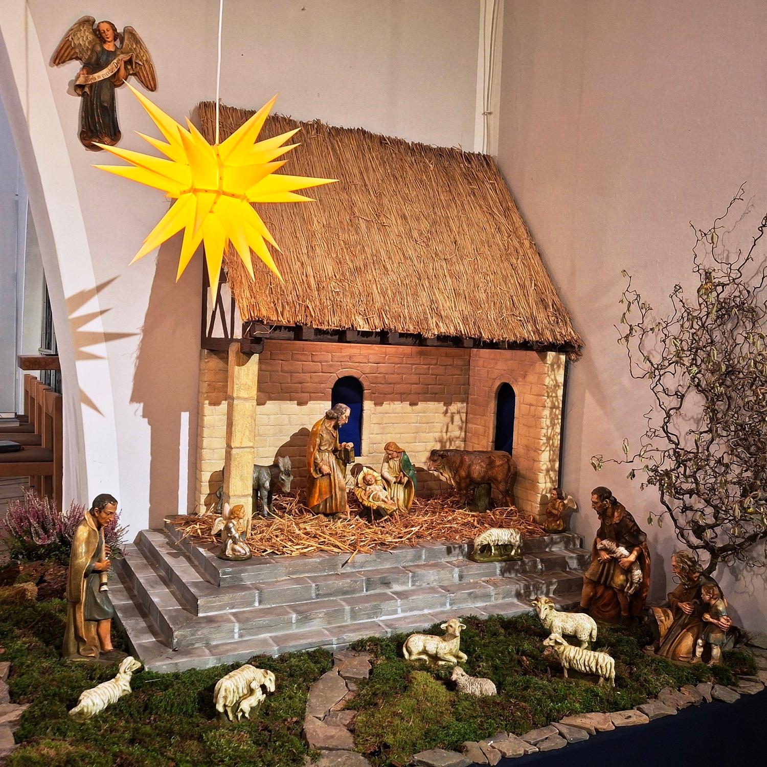 Die Krippe ist rechts neben dem Altarrraum St. Beatus zu sehen, sie besteht aus einem großen offenen Stall mit Strohdach, zu dem Stufen hinaufführen. Unten um die Stufen ist Moos, in dem Hirten mit ihren Schafen zu sehen sind. In dem Stall  sind Maria, Josef, das Jesuskind in der Krippe sowie ein Ochse und ein Esel zu sehen. Im Vordergrund hängt ein Stern