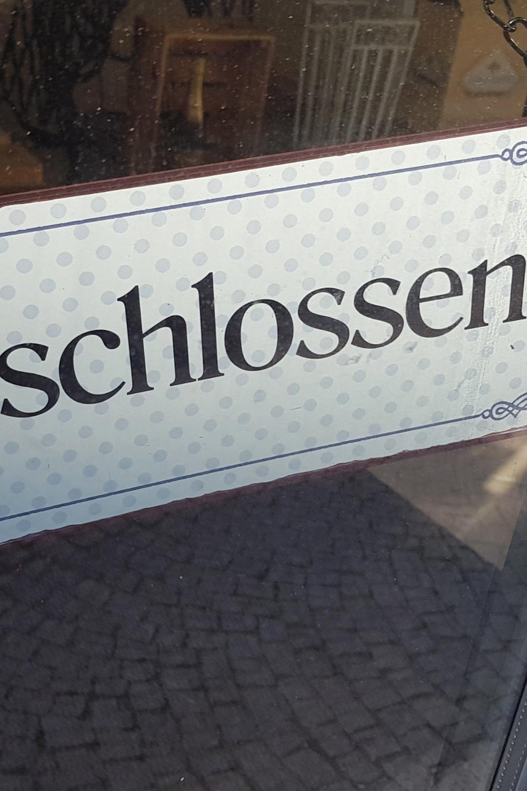 Ein Schild mit dem Schriftzug 'geschlossen' hängt an einer Tür.