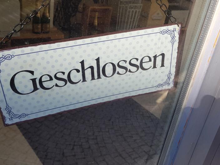 Ein Schild mit dem Schriftzug 'geschlossen' hängt an einer Tür.